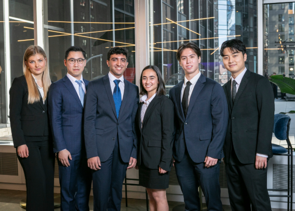 Six undergraduate men and women in suits pose for the camera.