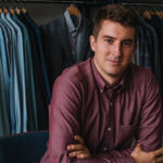 Image of Mac Bishop in front of his clothing line made out of merino wool