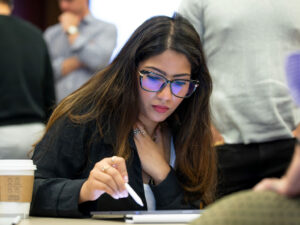 Female EMBA Metro student in class, looking at her laptop, during the summer residential session in Ithaca.