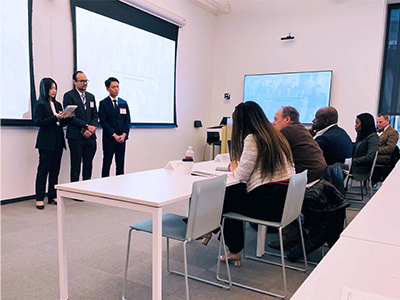 Three Cornell team members presenting in front of a table of judges