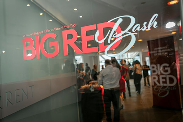 The Big Red Bash graphic identifier on a glass door leading into the reception area of a banquet room.
