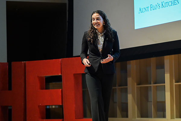 A woman dressed in business attire speaking on stage.