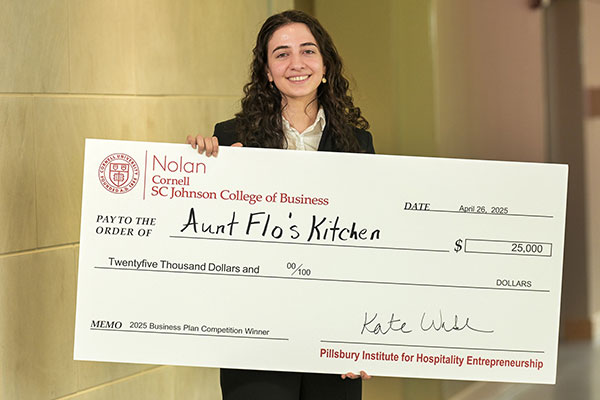 Armita Jamshidi ’25 holding a novelty check for $25,000 made out to Aunt Flo's Kitchen.