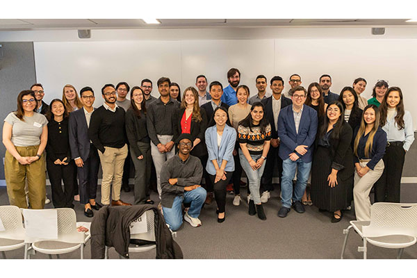 A large group photo of about 30 students and researchers posing for a photo and smiling.