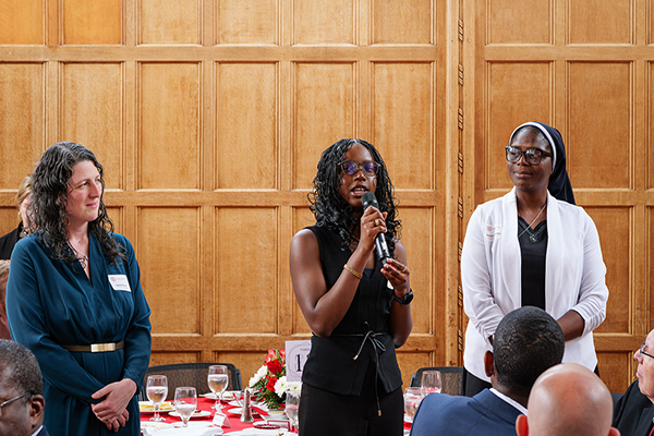 Professor Daniella Scur, Nneoma, and Rev. Sr. Matilda Adeboye of Louisville Girls High School in Nigeria, standing at the front of the room speaking at the Merrill Presidential Scholar luncheon.