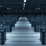 Image of a clean, modern room filled with rows of servers, glowing with blue and green lights