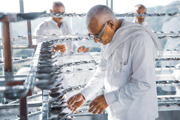 Sri Lankan workers craft oil lamps and lamp wicks as they move through a factory.