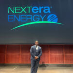 A picture of Jacob Hyppolite in front of a NextEra backdrop.