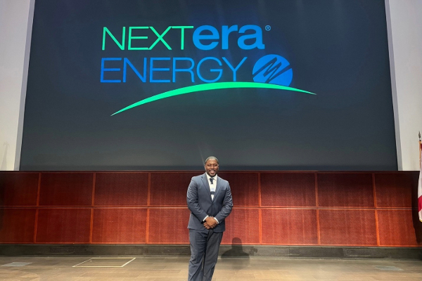 A picture of Jacob Hyppolite in front of a NextEra backdrop.