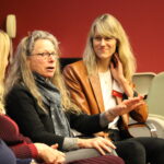 depiction of panelists answering a question from the crowd