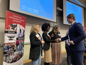 Cornell Business Impact Symposium 2025 depicting the investing pitch competition judges shaking hands with participants.