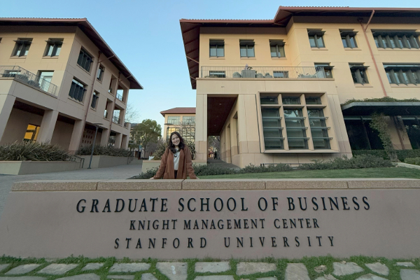 Vanessa Purnawan MBA ’26 standing in front of the Stanford Graduate School of Business sign at the Knight Management Center