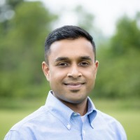 Professional headshot of Raghunandhan Reddy smiling with a blurred green background.