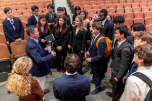 A crowd of students gathers around Dominic Chu. 