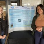 Prerana Reddy and Colby Snyder smiling and standing in front of their poster project