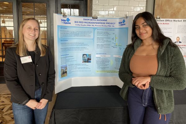 Prerana Reddy and Colby Snyder smiling and standing in front of their poster project