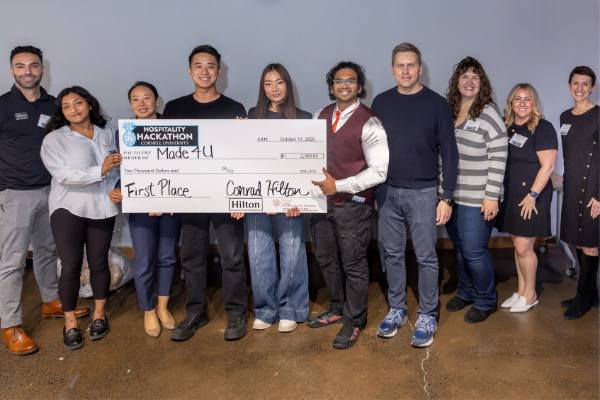 People stand in a line holding a giant prize check.