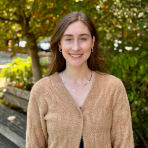 Diana Buckley stands in front of a tree and bench.