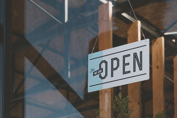 Open sign hanging in a store window.
