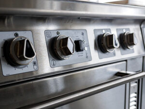 A close-up of diamond and triangle shaped knobs on the front of an induction stove.