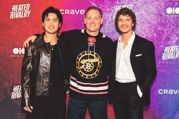 Stockman (center) with the stars of “Heated Rivalry,” Hudson Williams (left) and Connor Storrie. Stockman is wearing the jersey of the show’s fictional Boston Raiders