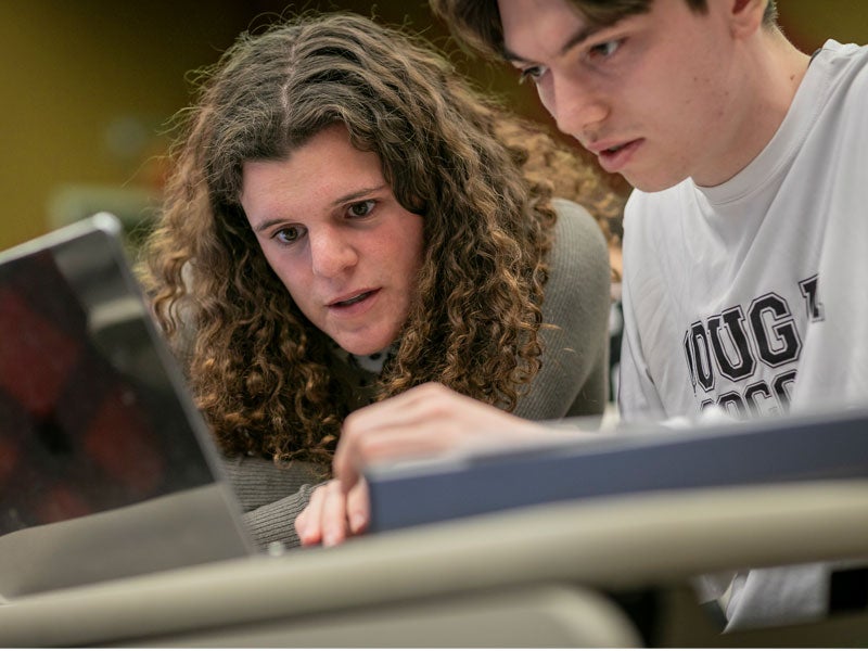 Students collaborating on project on laptop