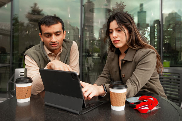 Male and female professionals looking at a laptop