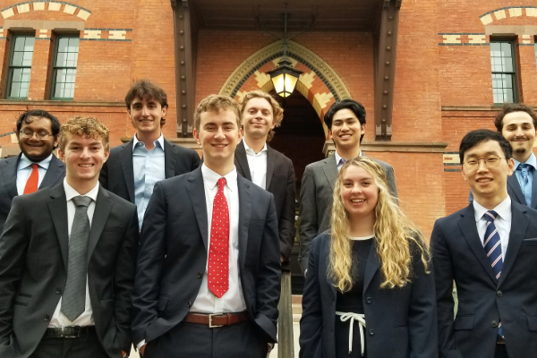 Nine undergraduate students standing in front of Sage Hall on campus