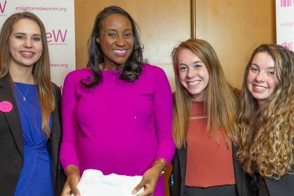 Four women standing in front of banners at an event