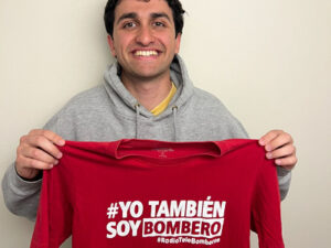 Kiran O'Kelly holding his Bomberos Tarapoto t-shirt