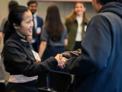 Tika Diagnestya smiling and shaking hands with another finalist