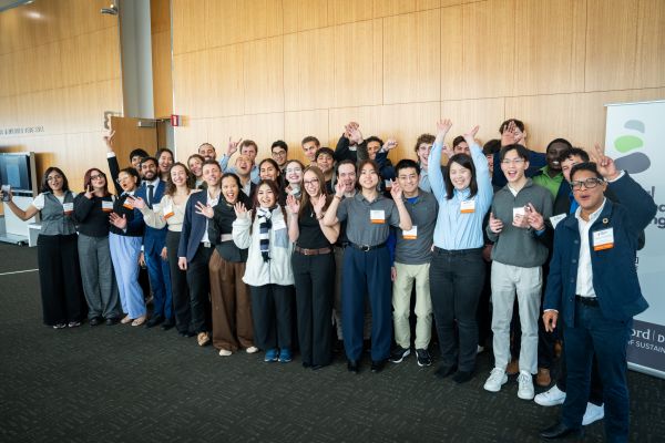 Global Sustainability Challenge participants smiling and waving hands in the air for a group shot