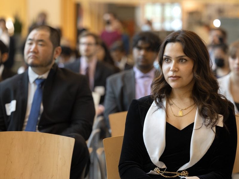 A woman pays attention, seated at a conference
