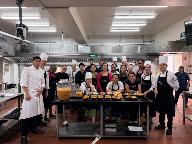 Students pose in a test kitchen with their product.