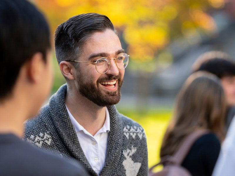 PhD Student talking with other students outside