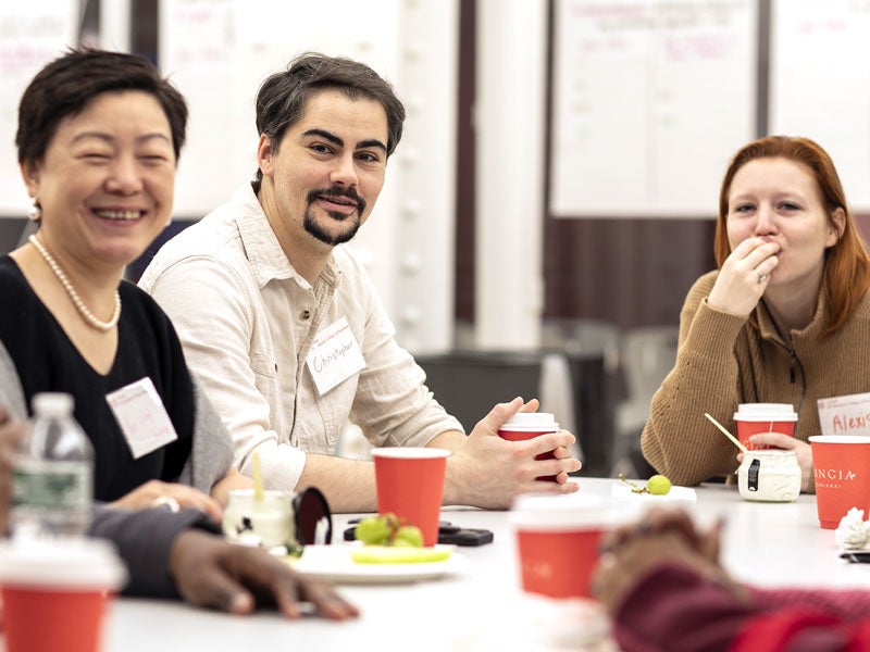 Three EMBA students eating at table