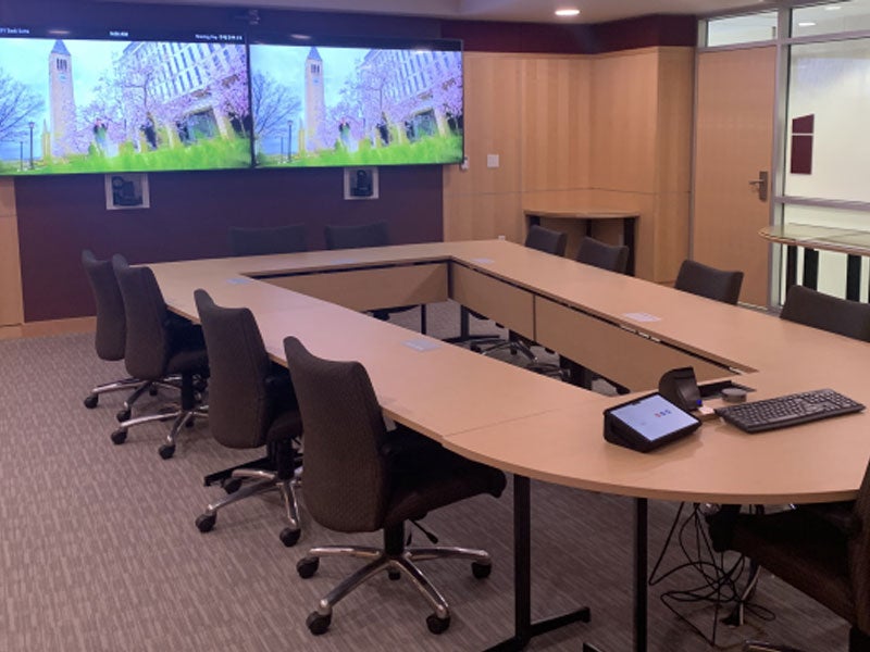 Sack Family space boardroom with two tv monitors, conference table, chairs, conferencing capability