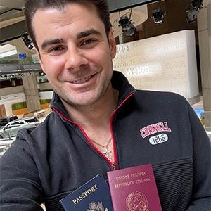 Image of Guzzo at the Renaissance Center in Detroit, Michigan, where the Consulate of Italy is located, displaying two passports.