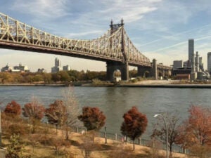 Queensboro Bridge over the East River as seen from Cornell Tech, with Queens in the background on a sunny day.