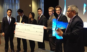 Students holding the winning price from the Real Estate Case Competition