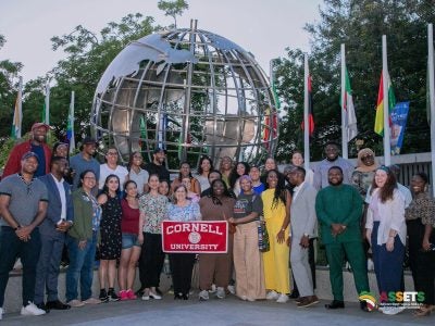Large group of Cornell students in Ghana holding a Cornell banner.