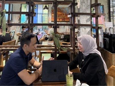 Pera Sihite, seated on right, with a man and woman in a lounge space.