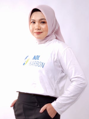 Pera Sihite standing in front of a light background wearing a Nol Karbon shirt.