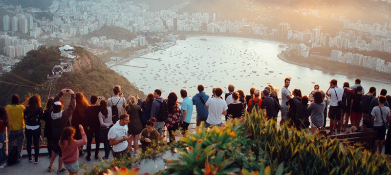 People gathered on a point overlooking a body of water.