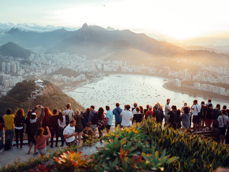 People gathered on a point overlooking a body of water.