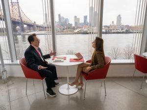Two people engage as they sit across the table from one another.