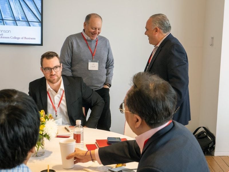 People at a conference sit around a table, talking.