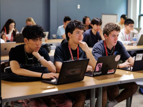 Three male high school students in a classroom.