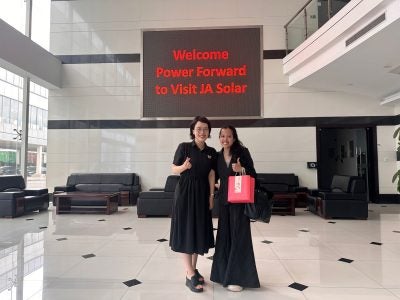 Tika Diagnestya and another female posing in one of the four largest solar PV factories in China.