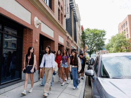 A group of high school students walking through Collegetown.